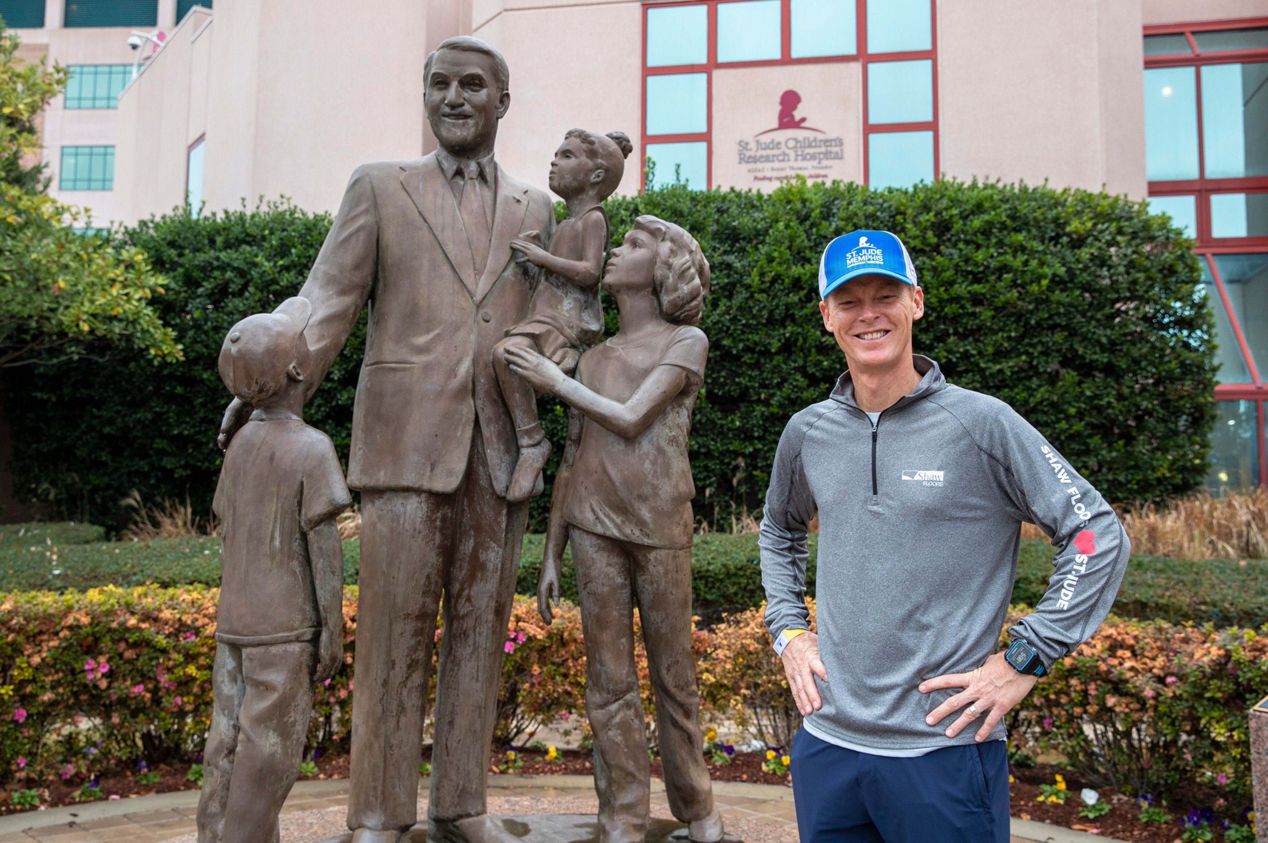 Scott standing next to statue from Solutions in West Fargo