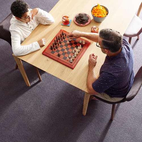 man and child playing chess from Solutions in West Fargo