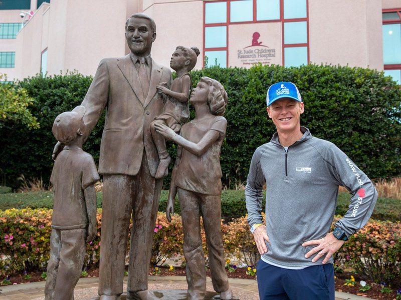 Scott standing next to statue from Solutions in West Fargo